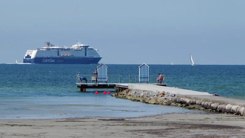 Fähre der Color Line auf der Ostsee hinter der Steiner Mole mit gestreiften Badehäuschen